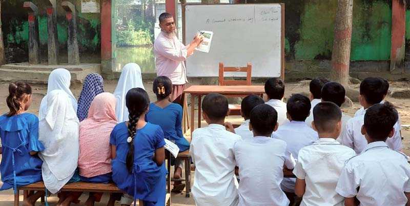 মুরাদনগরে শ্রেণি কক্ষের অভাবে খোলা মাঠে শিক্ষার্থীদের পাঠদান